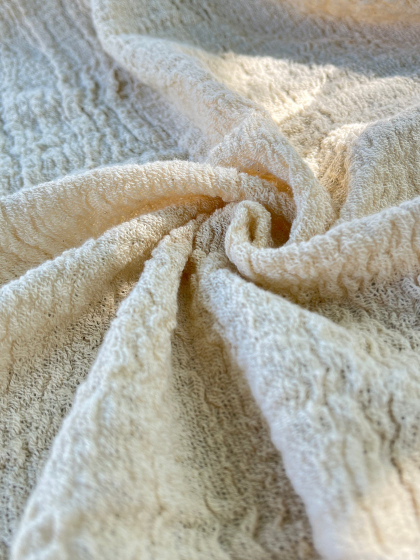 Tissu en coton froissé extensible neutre, surface texturée, tissu en coton ivoire blanc cassé, aspect tricoté.