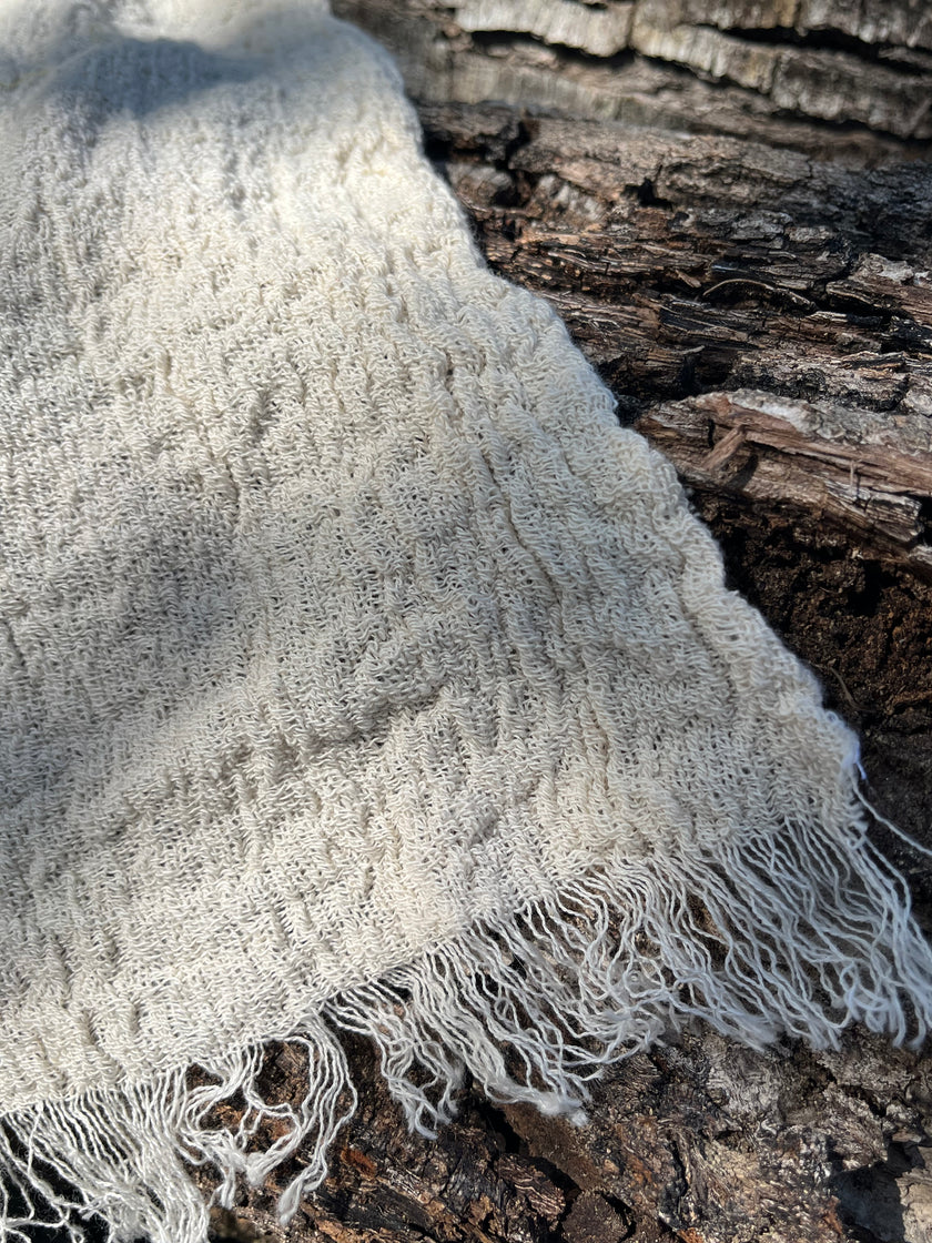 Tissu en coton froissé extensible neutre, surface texturée, tissu en coton ivoire blanc cassé, aspect tricoté.