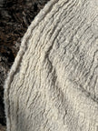 Tissu en coton froissé extensible neutre, surface texturée, tissu en coton ivoire blanc cassé, aspect tricoté.