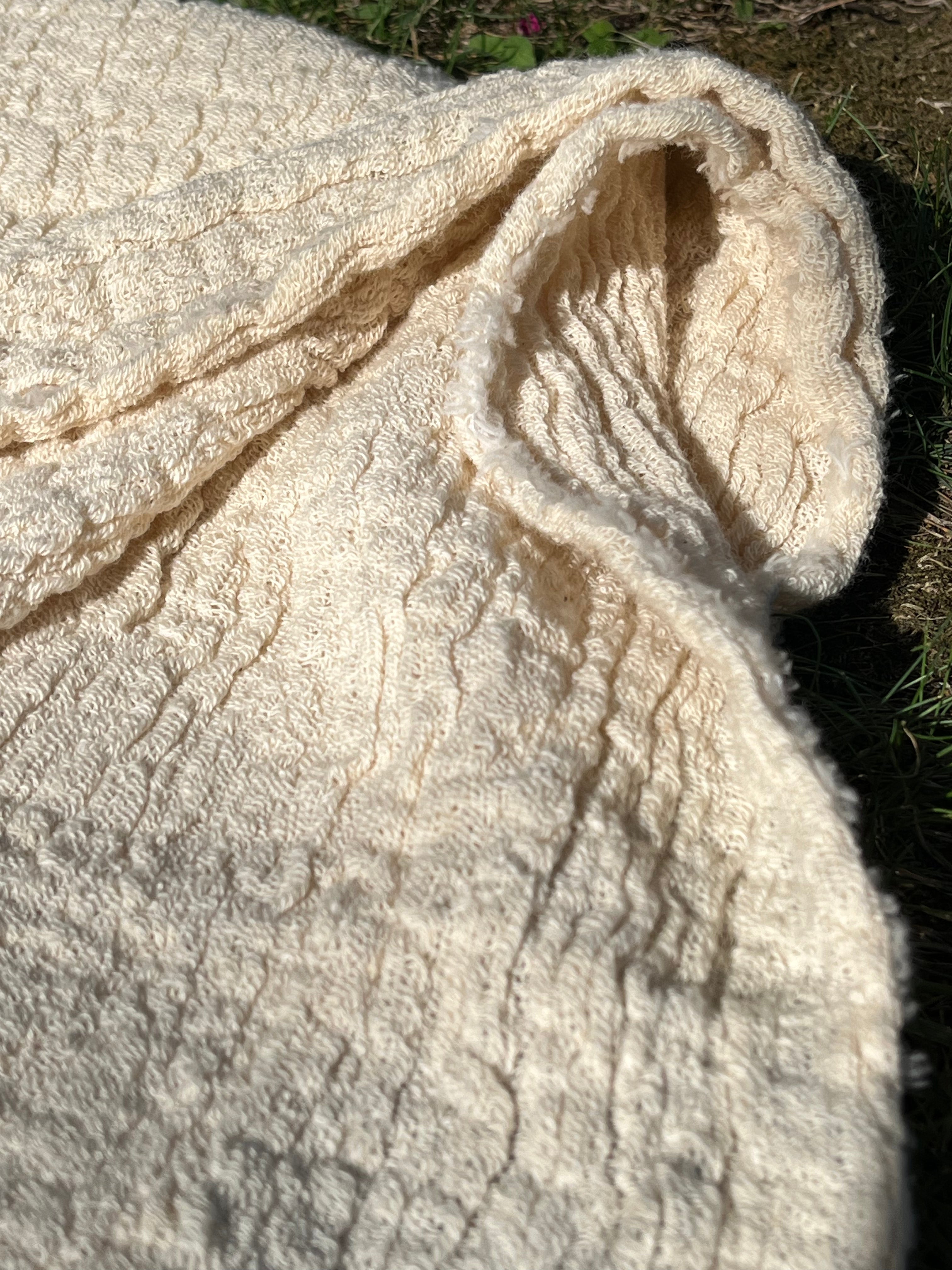 Tissu en coton froissé extensible neutre, surface texturée, tissu en coton ivoire blanc cassé, aspect tricoté.