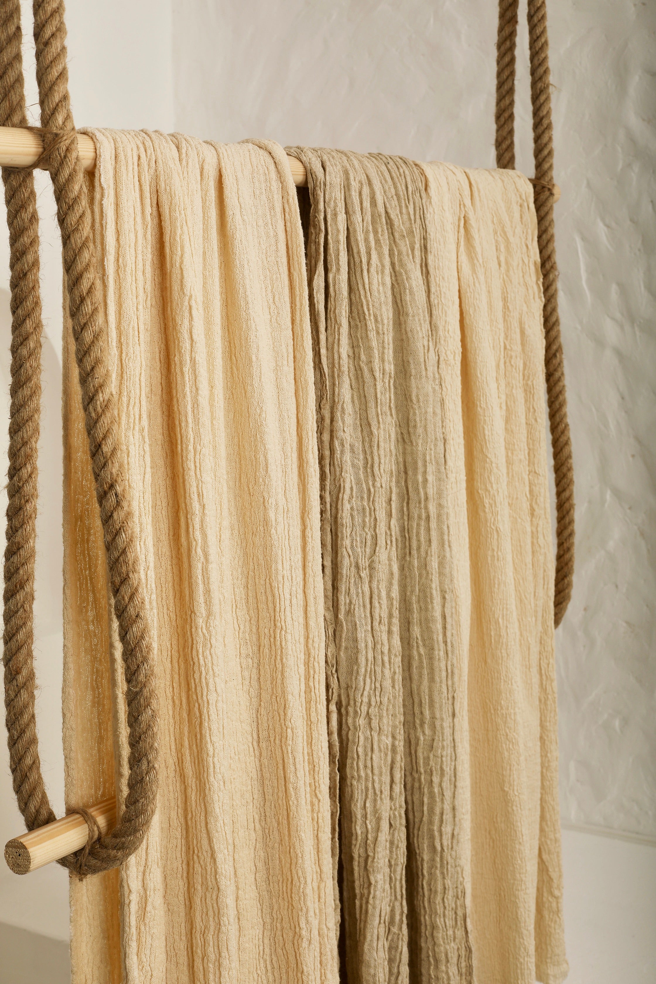Tissu en coton froissé extensible neutre, surface texturée, tissu en coton ivoire blanc cassé, aspect tricoté.