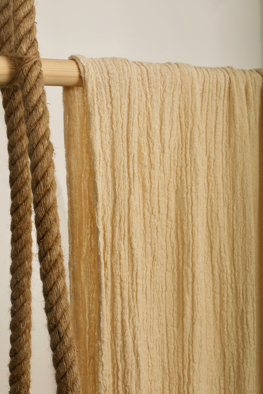 Tissu en coton froissé extensible neutre, surface texturée, tissu en coton ivoire blanc cassé, aspect tricoté.