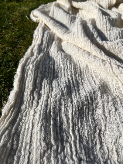 Tissu en coton froissé extensible neutre, surface texturée, tissu en coton ivoire blanc cassé, aspect tricoté.