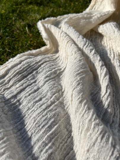 Tissu en coton froissé extensible neutre, surface texturée, tissu en coton ivoire blanc cassé, aspect tricoté.