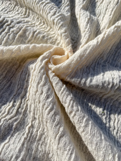 Tissu en coton froissé extensible neutre, surface texturée, tissu en coton ivoire blanc cassé, aspect tricoté.